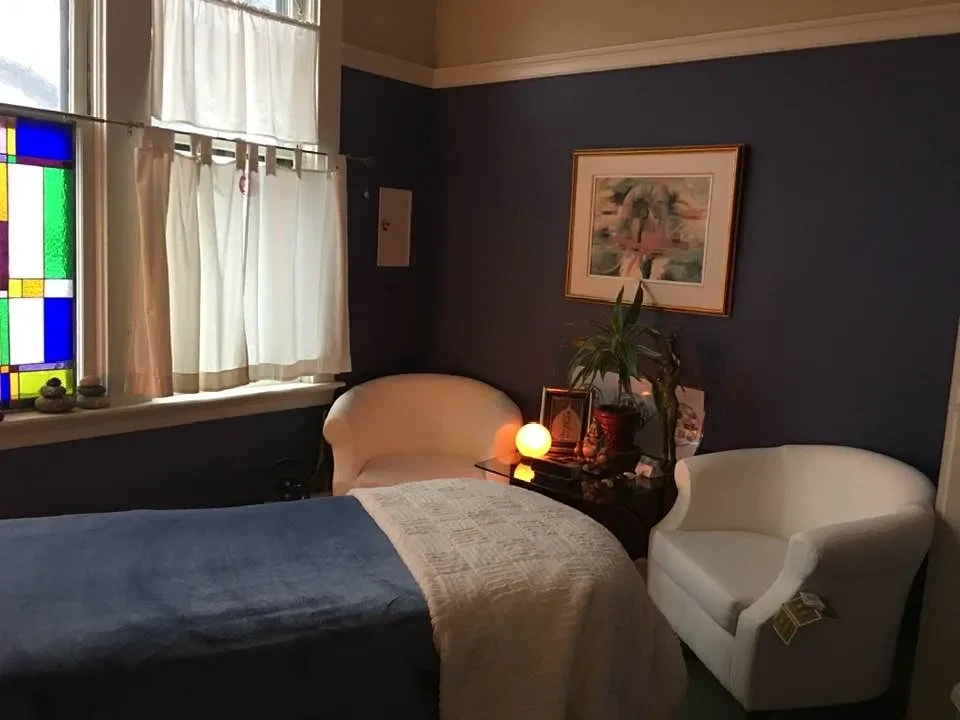 Warm massage therapy room with stained glass window
